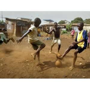  Young Children Play Soccer on a Dirt Pitch by the Side of 